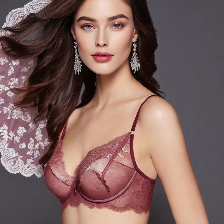 Elegant woman in maroon lace-trimmed bra with drop earrings