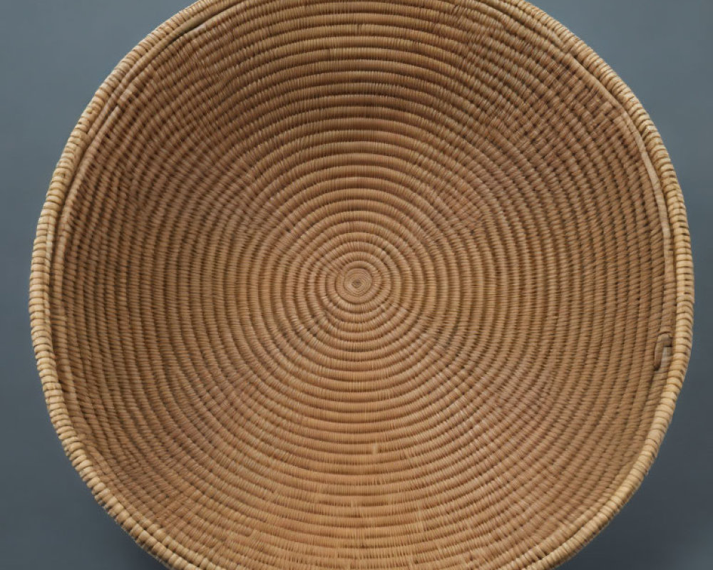 Spiral-Patterned Round Brown Basket on Grey Background