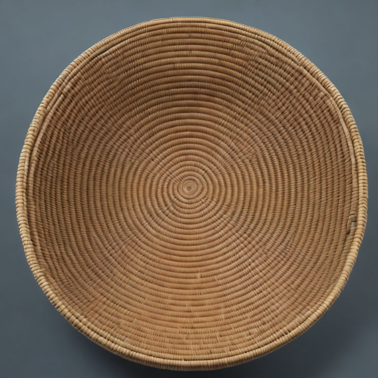 Spiral-Patterned Round Brown Basket on Grey Background