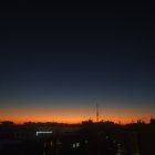 Starry nightscape with silhouetted buildings and orange horizon