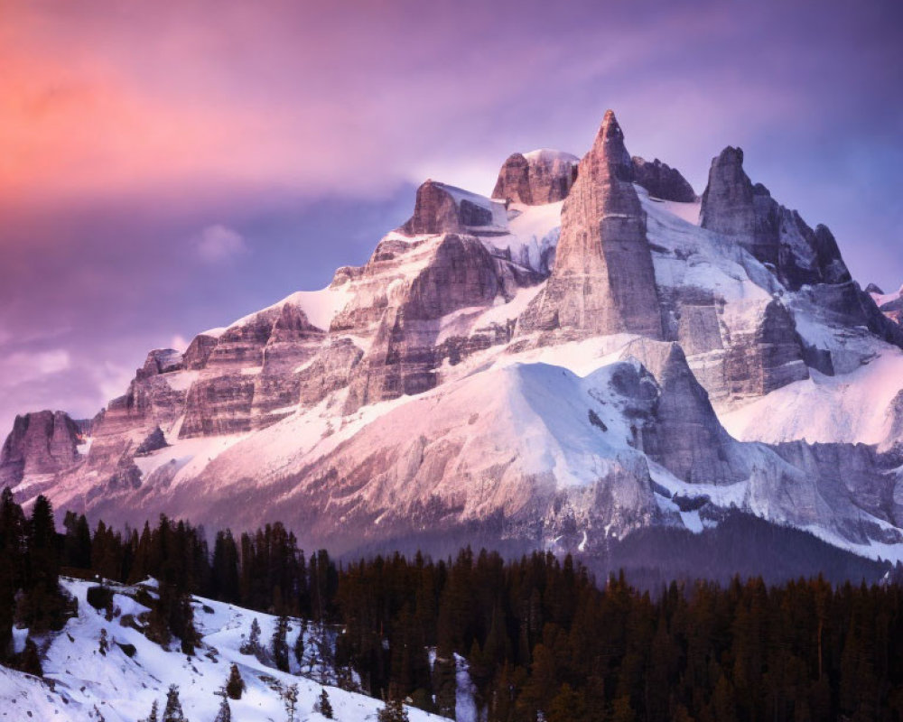 Snow-capped mountain peaks at sunrise with purple and orange sky