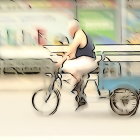 Colorful painting of person on tricycle with cargo compartment