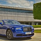 Luxury Blue Car Parked in Front of Wave-Patterned Building