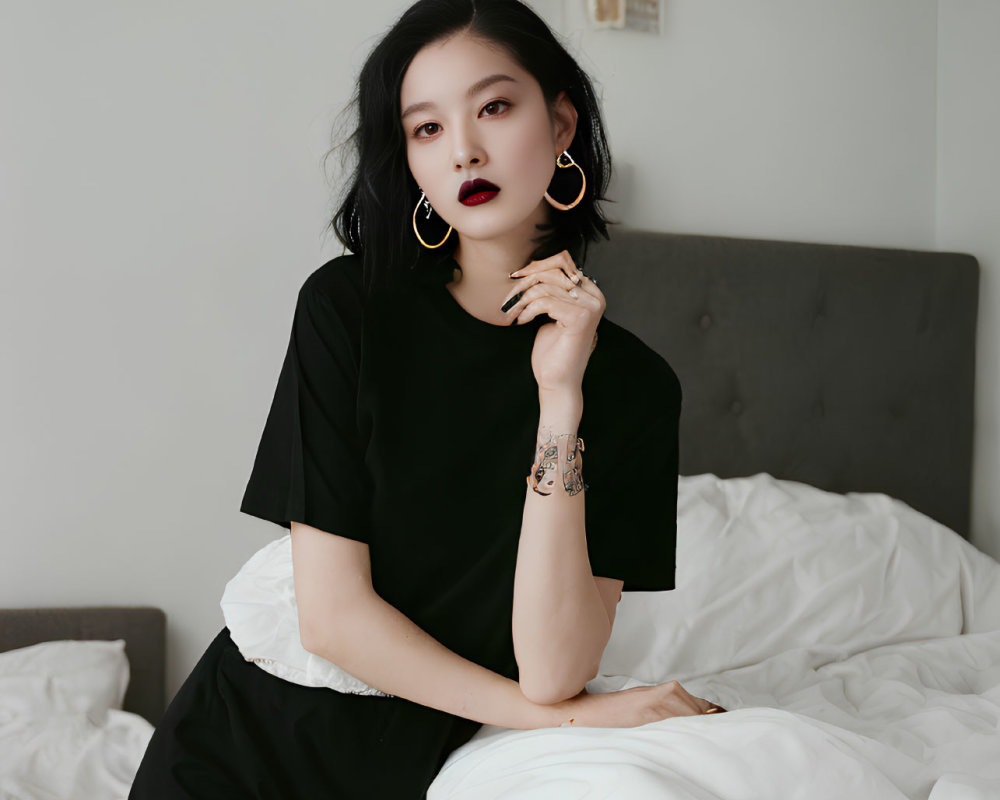 Woman in Dark Lipstick and Large Earrings Poses Thoughtfully on Bed