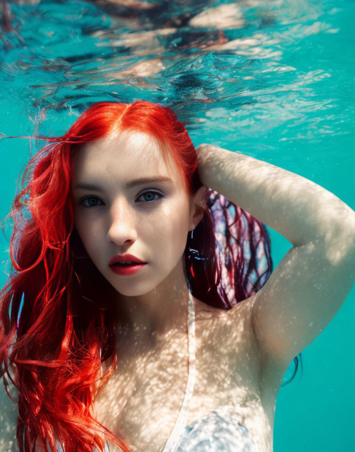 Red-haired woman partially submerged in blue water