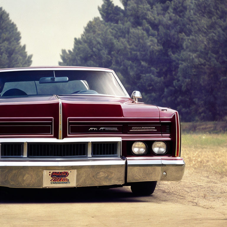 Vintage Red Car with Distinctive Grille and Square Headlights on Dusty Road