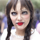 Woman with smoky eye makeup and braids in white lace outfit against natural backdrop