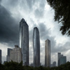 Urban skyline with skyscrapers under dramatic cloudy sky and green park.