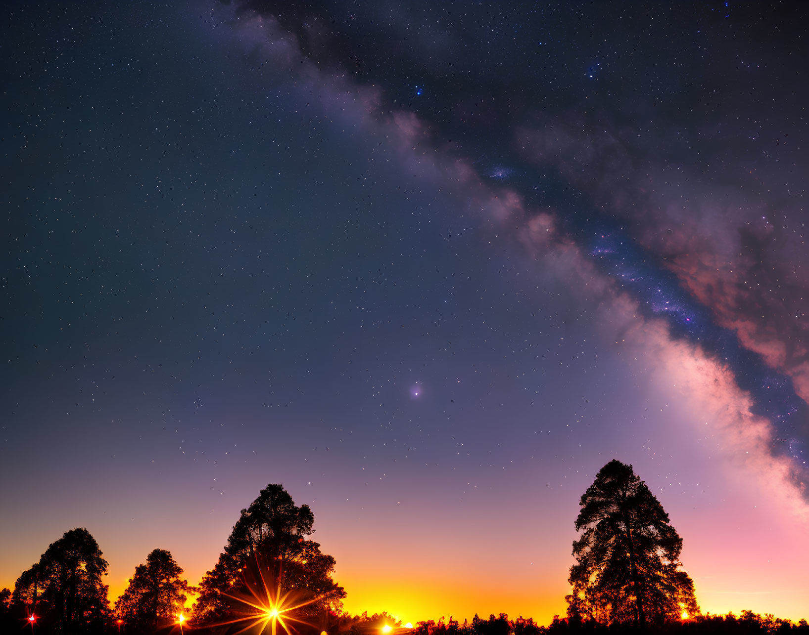 Twilight sky with Milky Way over silhouetted trees