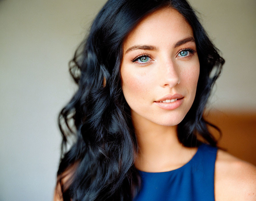 Portrait of a Woman with Long Dark Hair and Blue Eyes in Blue Top