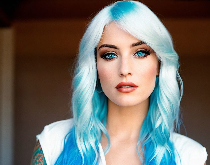 Vibrant blue-haired woman with striking eyes and tattoo gazes at camera