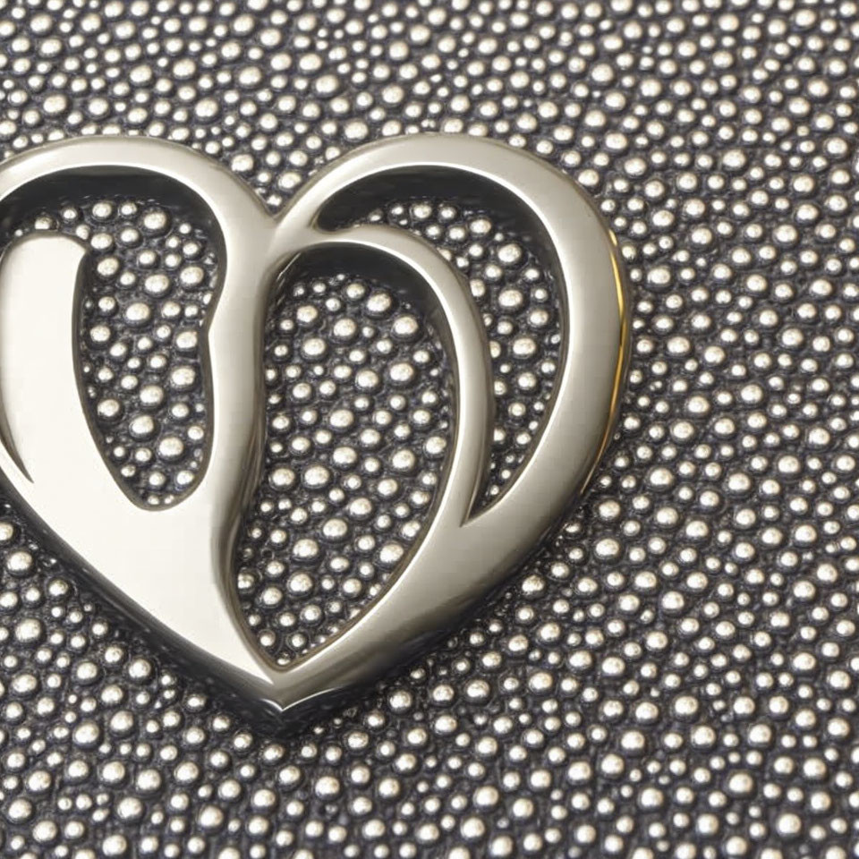 Silver Heart-Shaped Pendant on Textured Surface with Shiny Beads