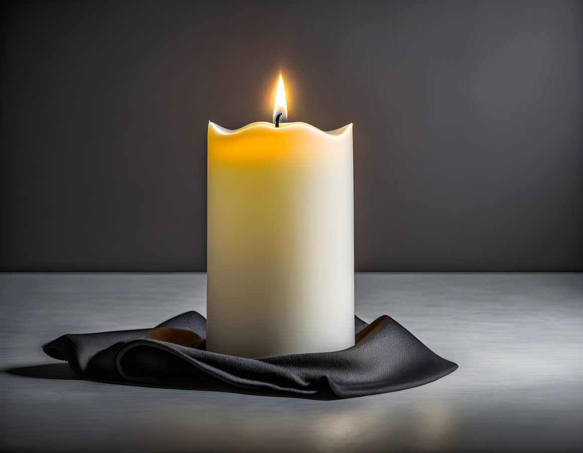 White candle with melting wax on dark cloth against gray background