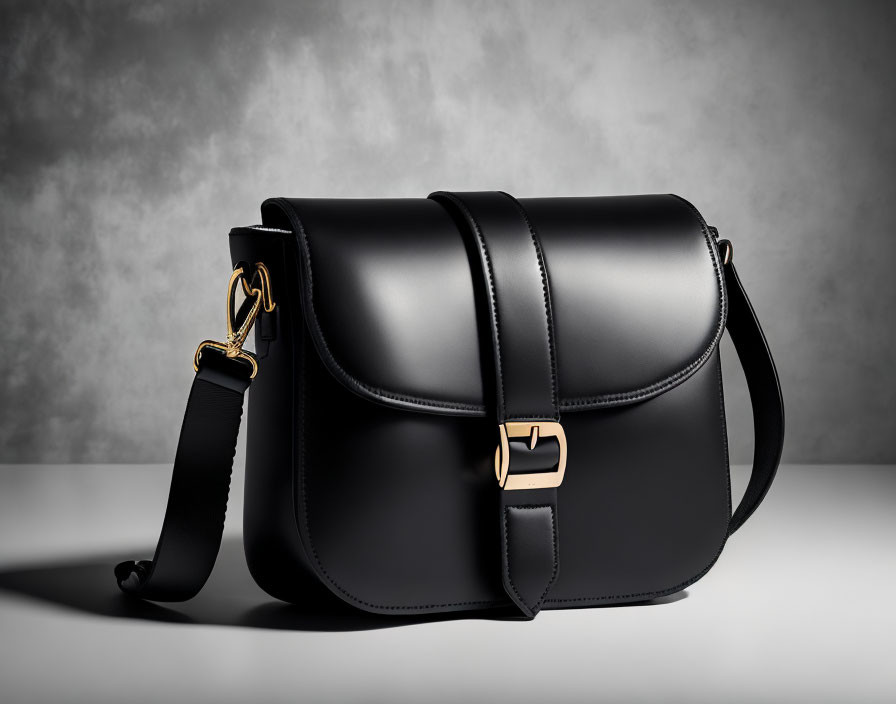 Black Leather Satchel with Gold-tone Hardware on Grey Background