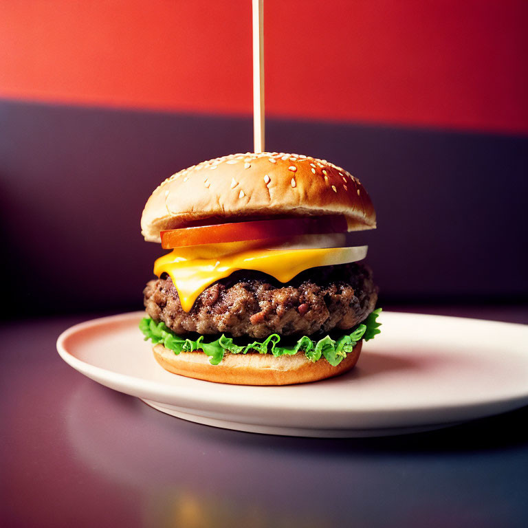 Cheeseburger with lettuce and cheese on sesame seed bun, red and purple backdrop