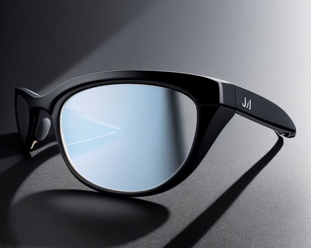 Black-framed sunglass with blue-tinted lens on grey surface