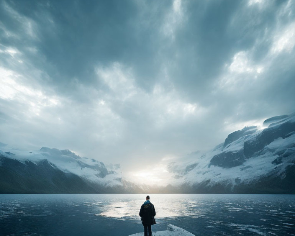 Person on Rock Overlooking Serene Lake & Mountains at Sunset