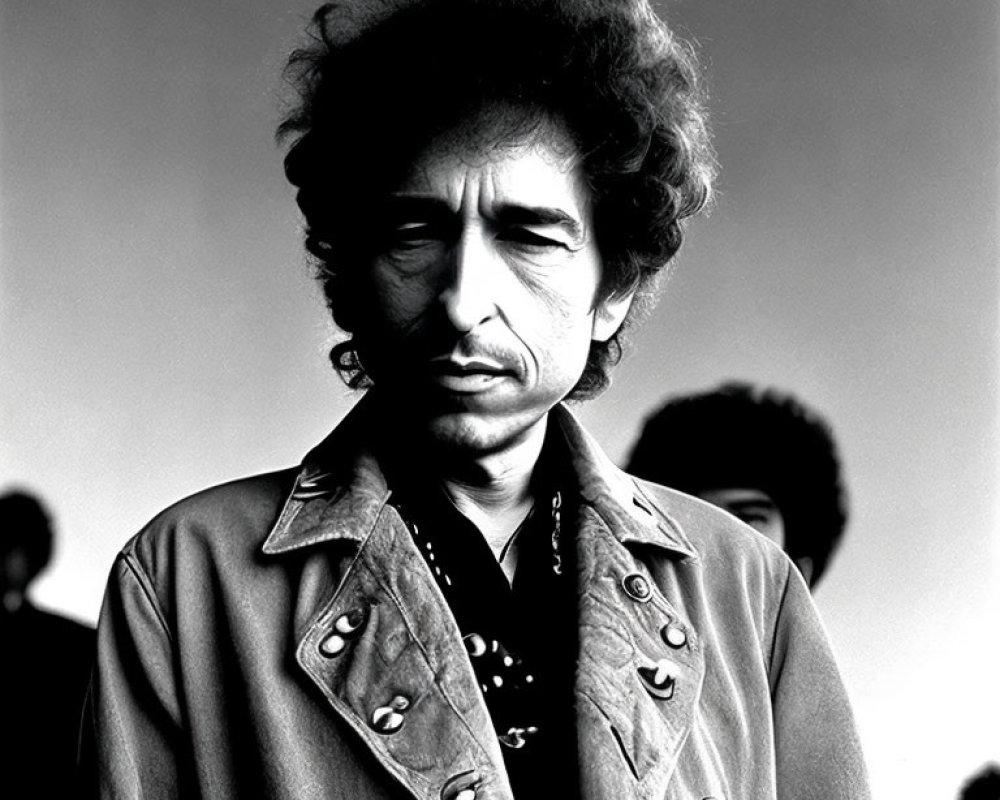 Monochrome portrait of man with curly hair in embellished jacket