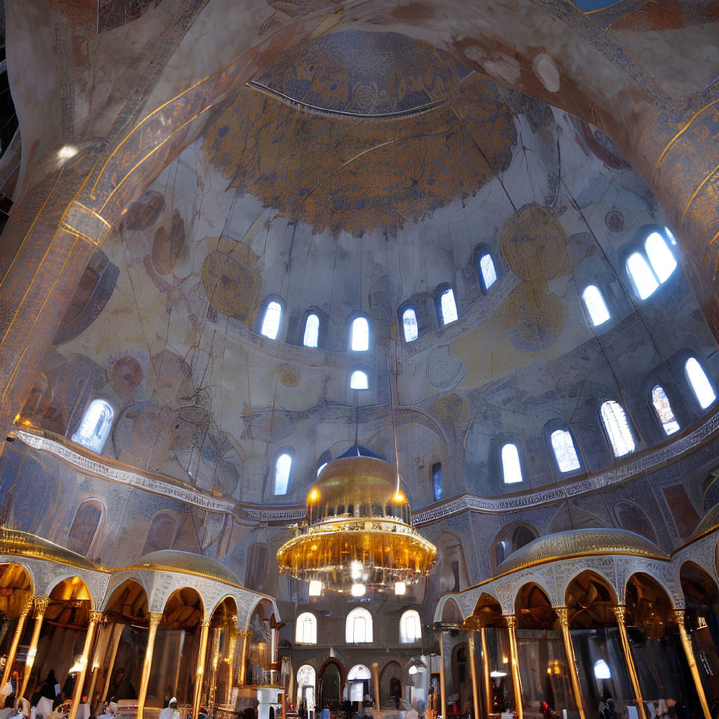 Grand historical building with golden dome, frescoes, and abundant natural light