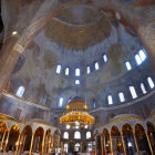 Grand historical building with golden dome, frescoes, and abundant natural light