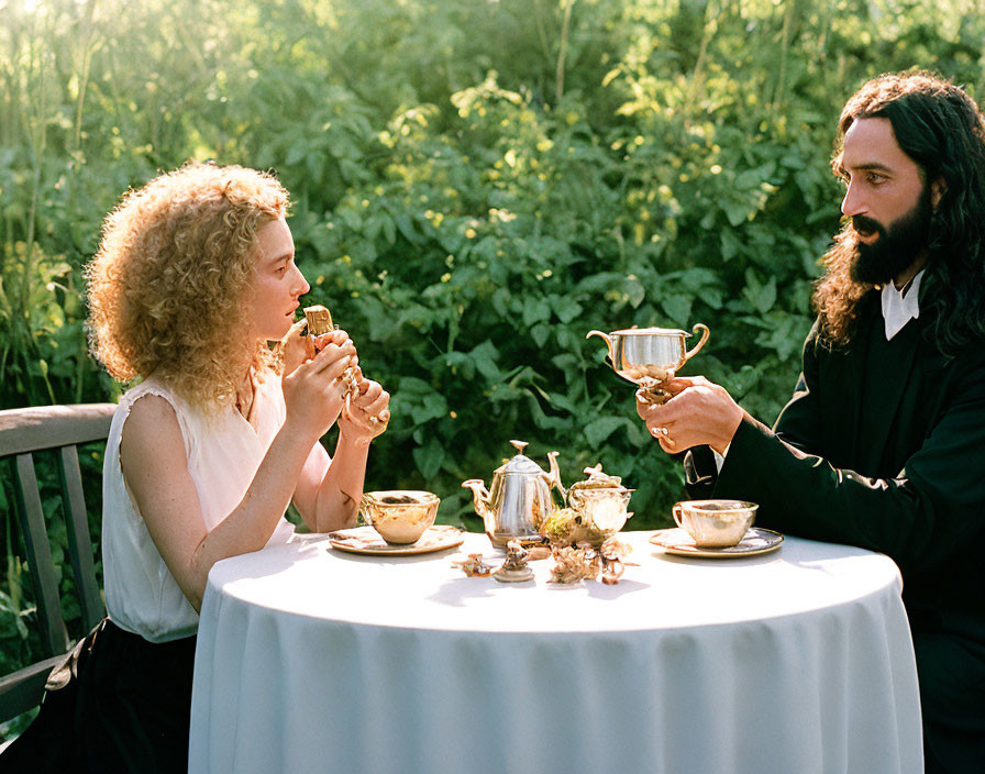 Two people chatting happily at outdoor tea party in lush garden