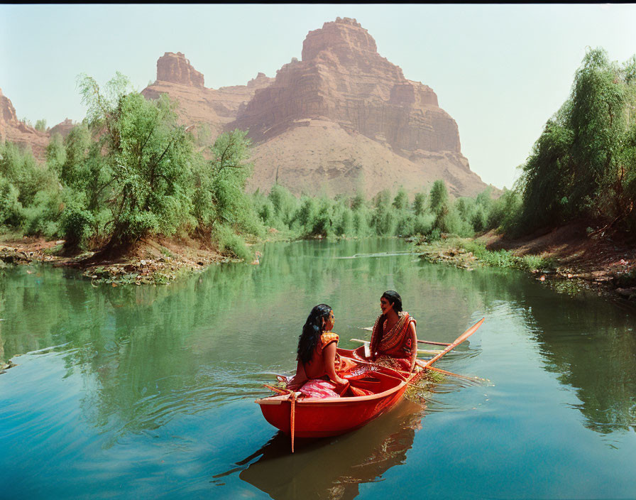 Traditional Attire Individuals in Red Canoe on Calm River