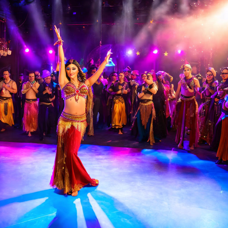 Female dancer in bejeweled costume leads vibrant belly dance on stage