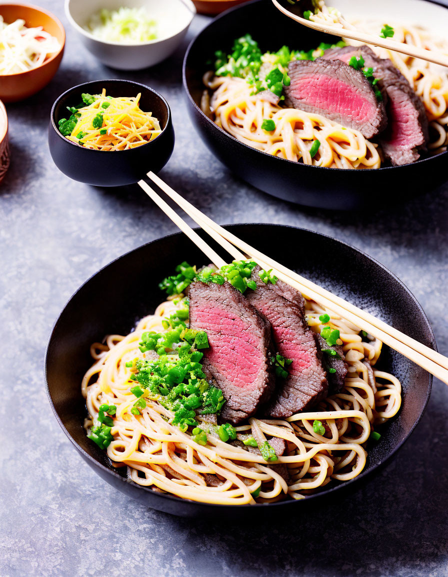 Sliced Beef Noodle Bowl with Green Onions and Chopsticks