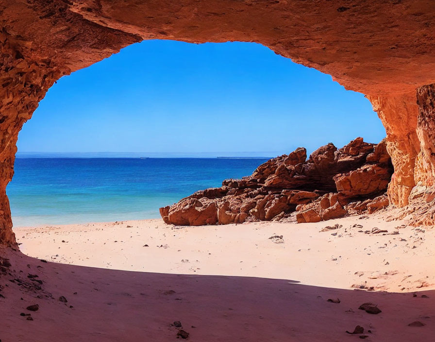 Scenic beach view through large cave opening