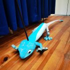 Blue Pedal Car with Airplane Design on Sparkle-Scattered Wooden Floor