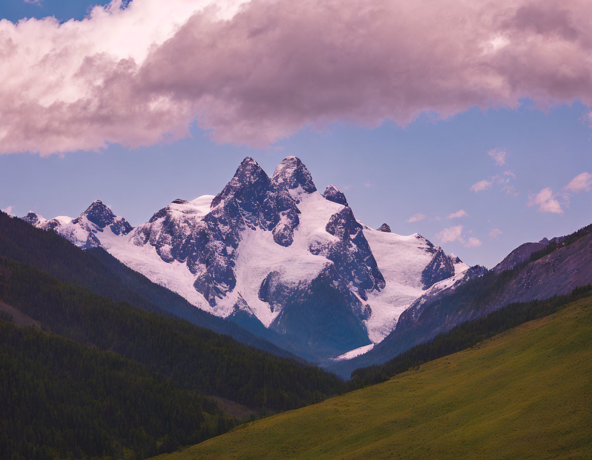 Majestic snow-capped mountain peaks under pink-tinged cloud landscape