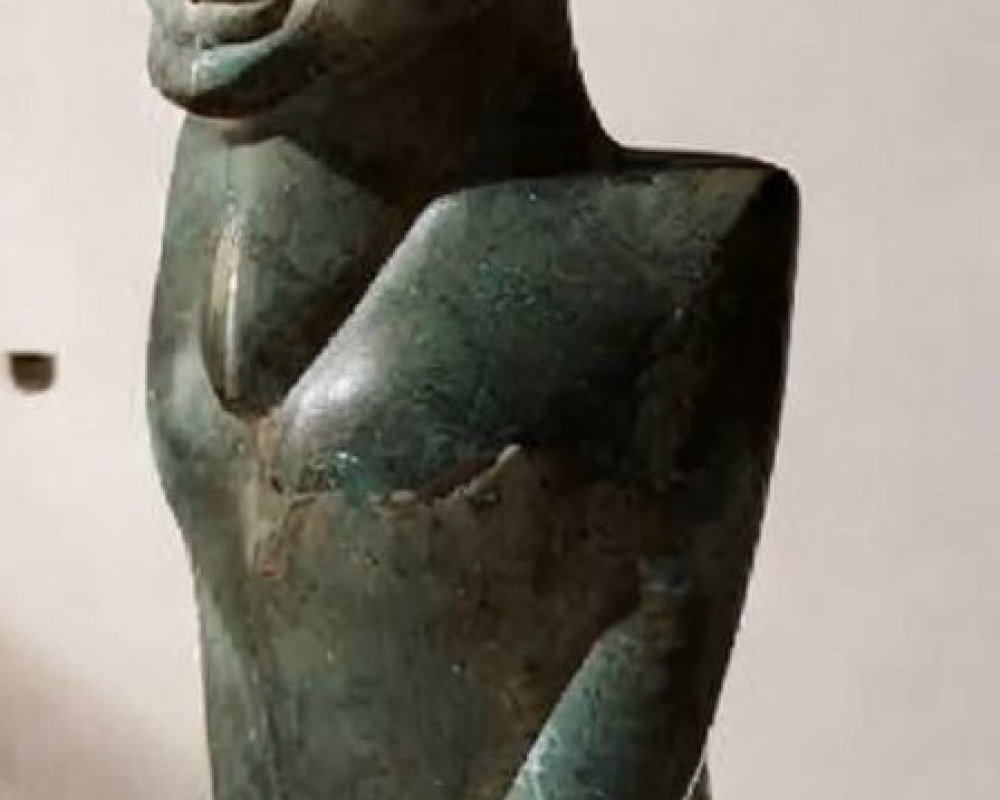 Bronze sculpture of slender figure with elongated ears and greenish patina