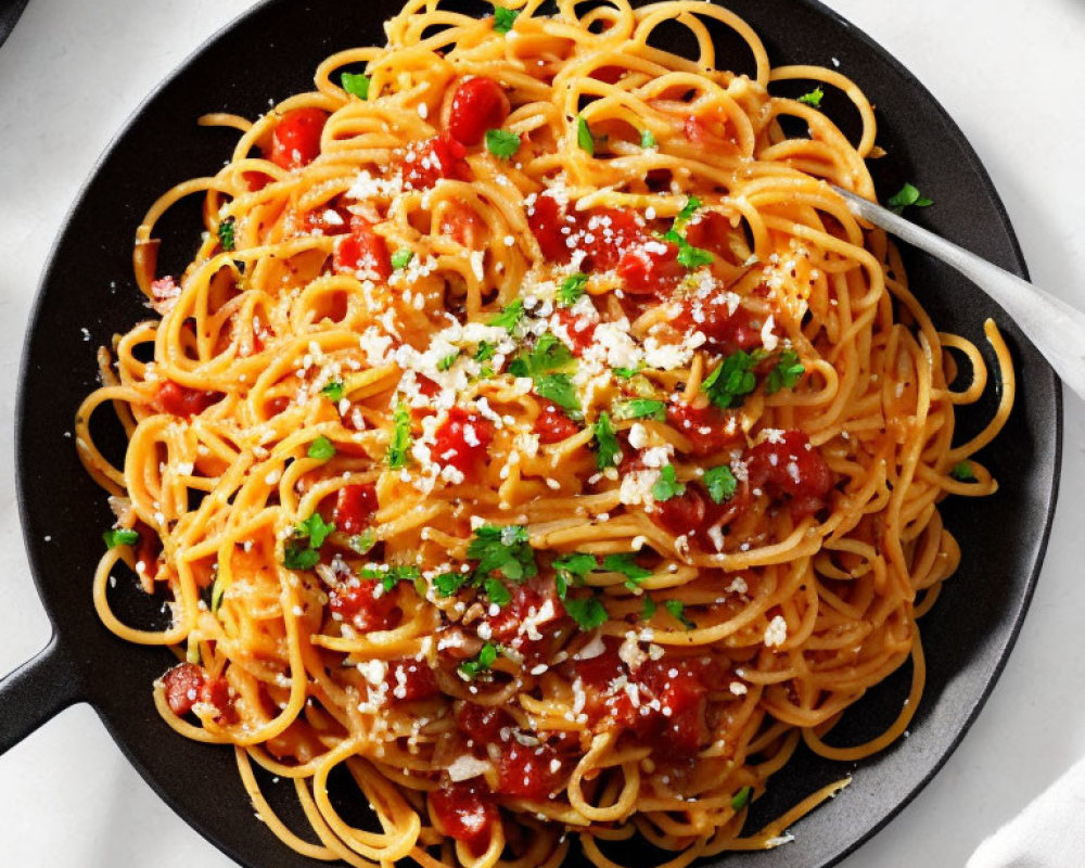 Skillet with spaghetti in tomato sauce, herbs, and cheese.