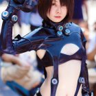 Futuristic armored figure in glossy costume under soft lighting