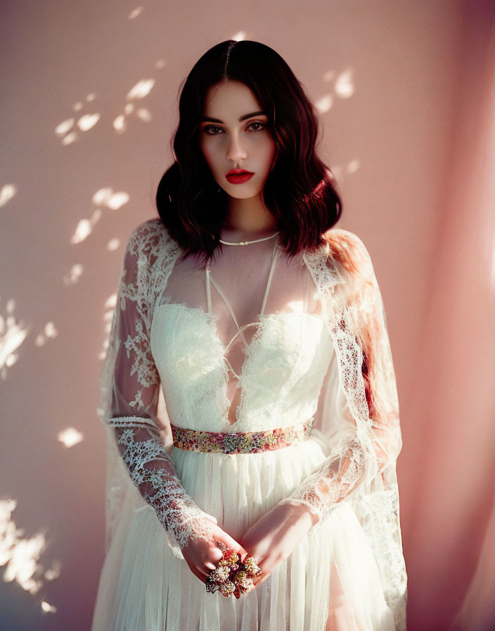 Woman in White Lace Dress with Red Lipstick on Soft Pink Background