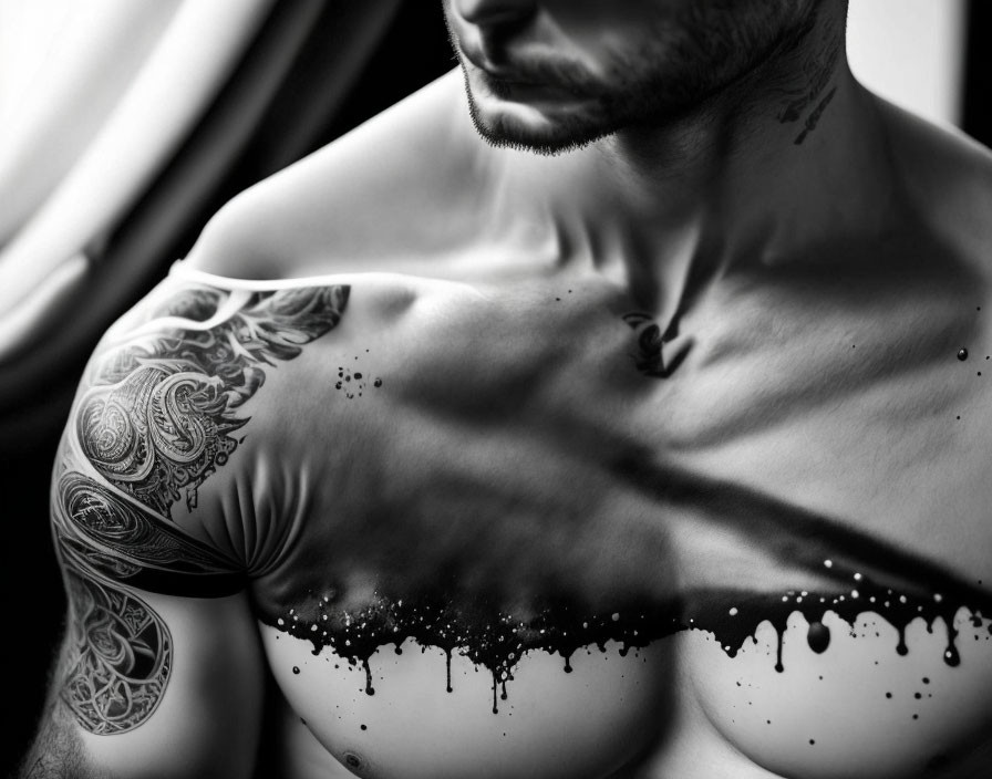 Detailed tattoo on shirtless man's upper arm with beard in close-up shot.