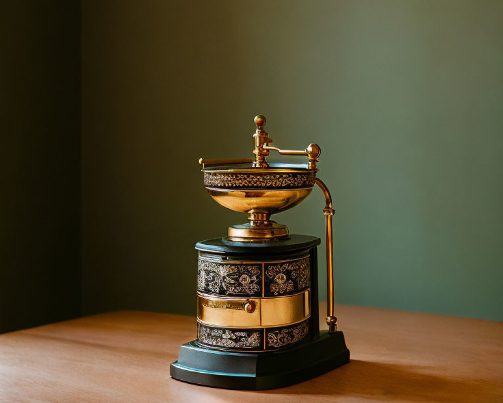 Vintage Ornate Coffee Grinder on Wooden Table with Green Wall