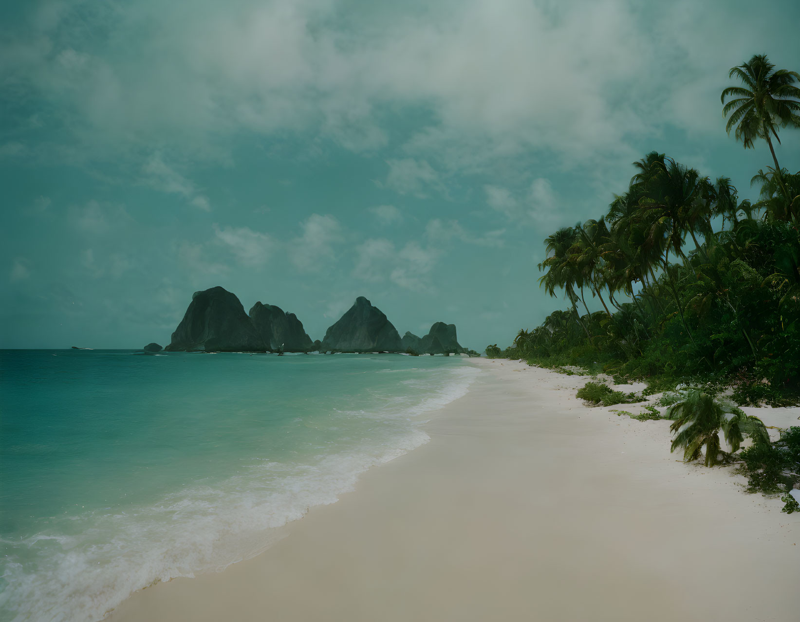 Tropical beach scene with palm trees, white sand, and rock formations