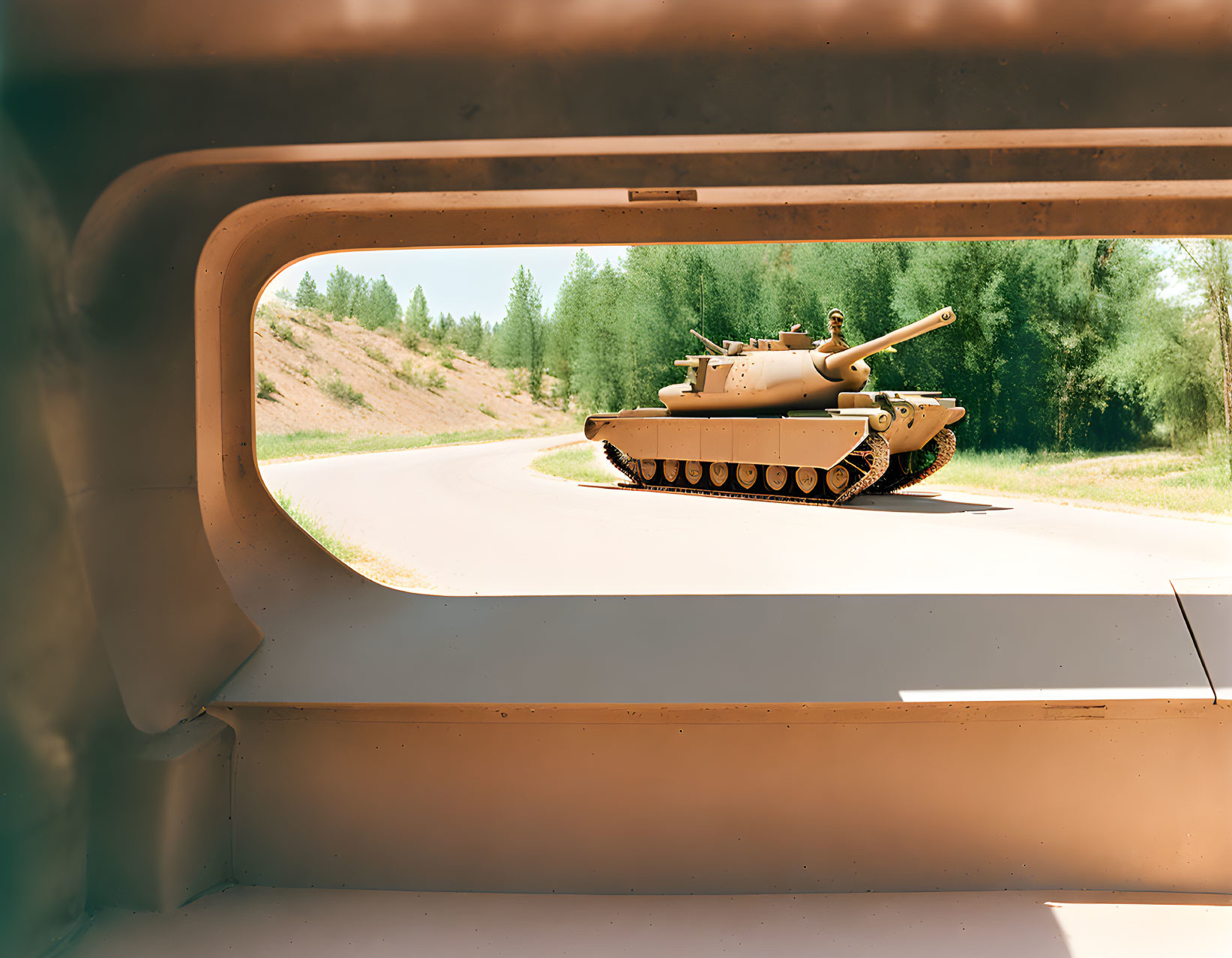 Military tank on road viewed from open hatch surrounded by greenery