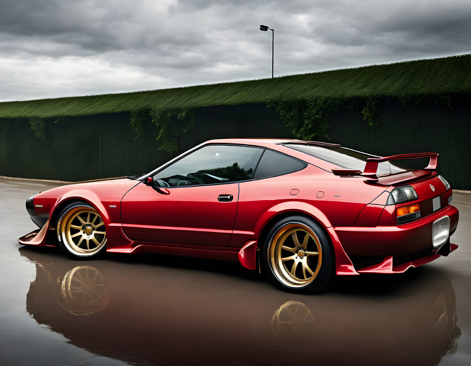 Red sports car with gold wheels and rear spoiler on wet surface displays sleek design