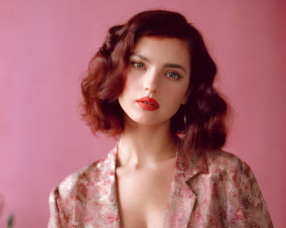 Woman with Short Wavy Brown Hair in Floral Garment on Pink Background