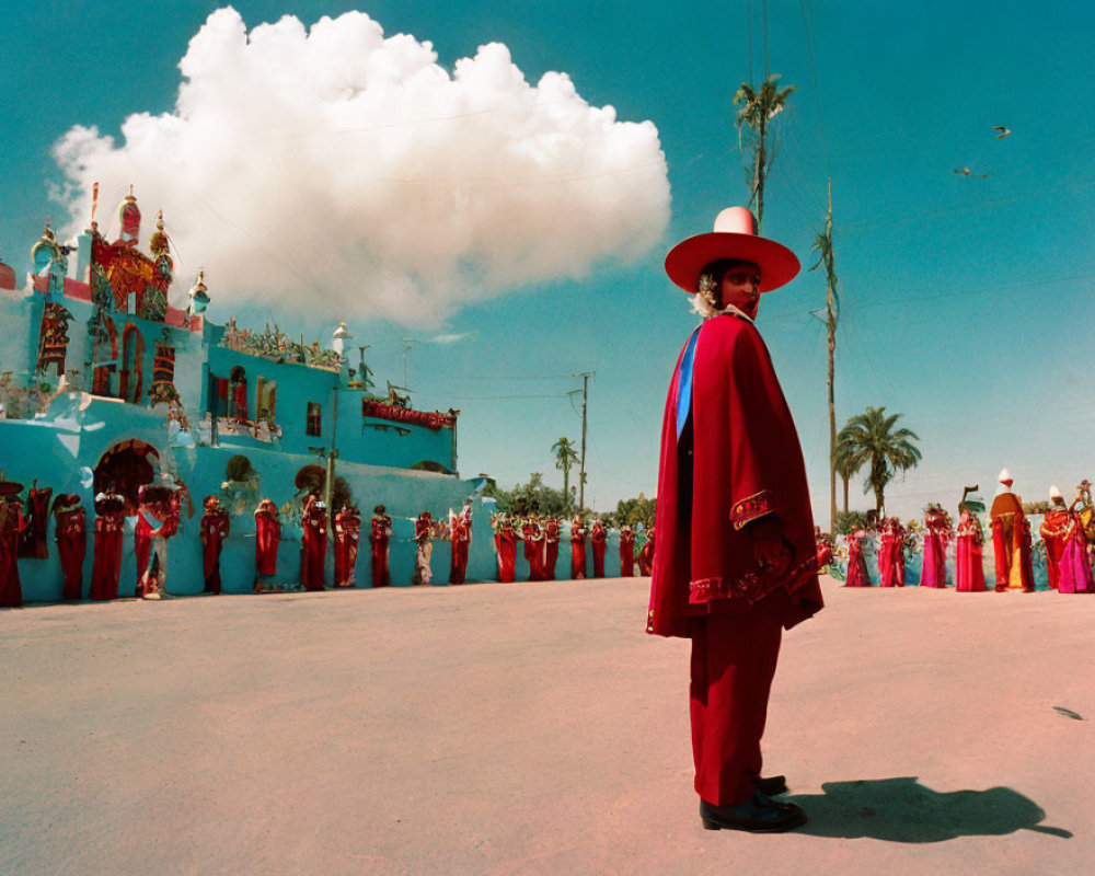 Traditional attired man with group in front of vibrant building under blue sky