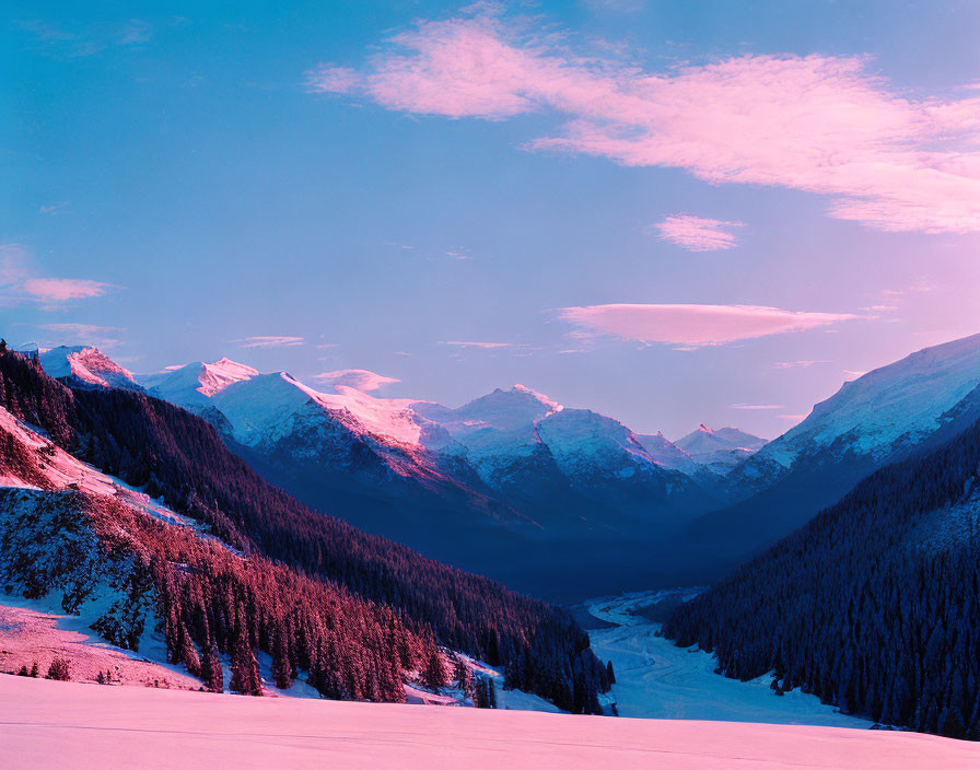 Snow-covered mountain range at sunrise with pink hues over forested valley