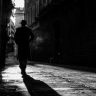 Silhouette of person in foggy street under streetlight