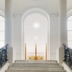 Grand, sunlit cathedral interior with towering pillars and tranquil pools