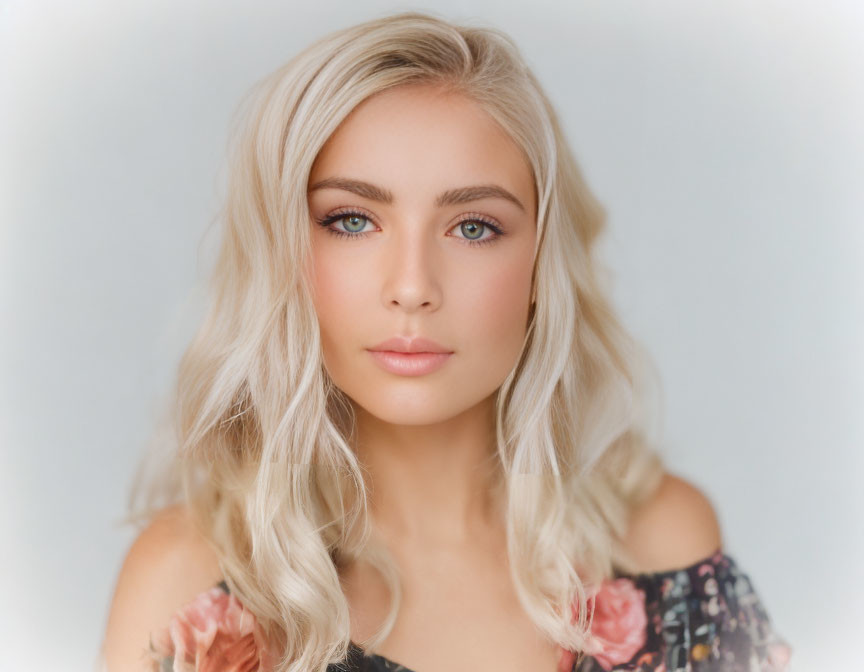 Blonde woman with wavy hair and blue eyes in floral top portrait