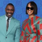 Man and woman in stylish attire against starry background: man in blue suit, woman in colorful outfit