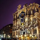 Golden building at night with starry sky and people in line