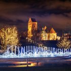 Moonlit classical building and bridge over tranquil water at night