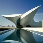 Surreal architectural structure with wing-like roofs reflected in calm water